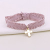 Croix gravée plaqué or sur ruban froufrou vieux rose